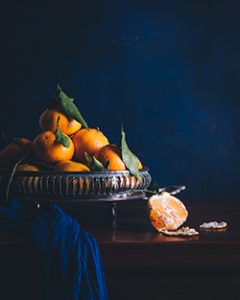 Bodegón de mandarinas, fondo azul oscuro.