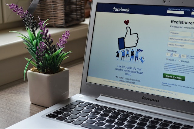 Un portátil mostrando en pantalla el icono de like de Facebook.